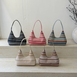 Close-up of five woven striped straw hobo bags in various colors for summer beach vacation