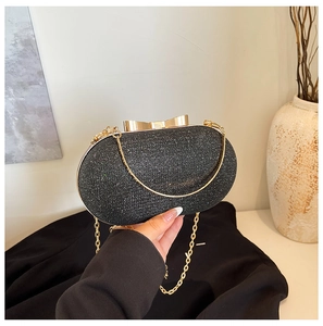 Detail of glitter evening clutch with golden bow clasp and metallic chain strap