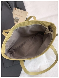 Top view of large capacity light green tote bag interior showing smooth zipper and gray lining