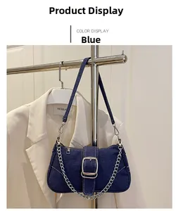 Detail of blue denim hobo bag featuring silver metal buckle closure and chain strap