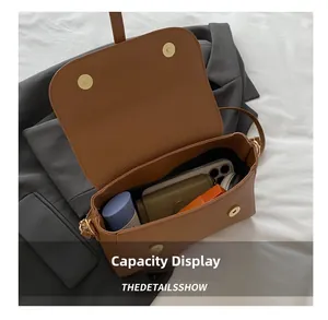 Interior view of brown lychee leather bag showing capacity for phone and cosmetics