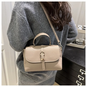 Side view of litchi texture leather crossbody bag with adjustable strap and buckle