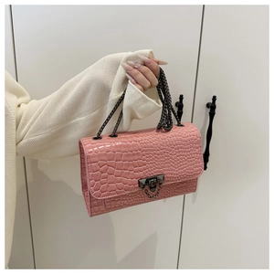 Detailed view of pink crocodile-embossed leather with dark metal chain and clasp
