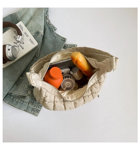Detail of spacious cream quilted tote bag interior holding water bottle and daily items