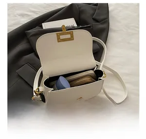 Internal view of a white leather crossbody bag showing its capacity for daily essentials