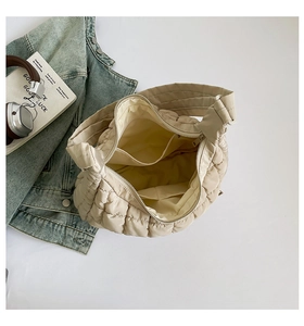 Detail view of the spacious interior of the beige quilted puffer tote bag with zipper