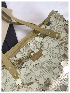 Close-up of silver sequins and leather strap details on a large fashion tote bag