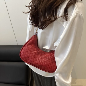 Red woven crescent shoulder bag with leather texture and golden metal hardware