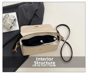 Detail showing the spacious main compartment and zipper inner pocket of the beige crossbody bag