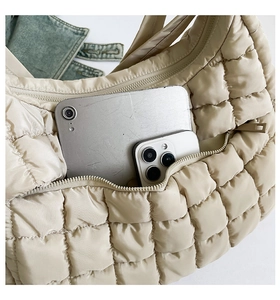 Detail of the oatmeal quilted tote bag interior showing spacious storage for tablet and phone