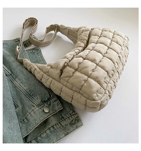 Close-up of beige quilted tote bag showing high-quality stitching and padded nylon texture