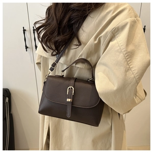 Detail view of deep brown lychee grain leather bag with vintage gold metal buckle