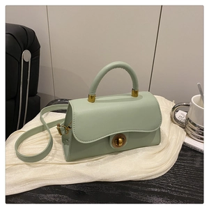 Detailansicht der salbeigrünen Handtasche mit vintage goldenem Drehverschluss und Ledergriff