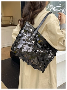 Detail of sequin tote bag with large silver discs, black leather handles and metal rivets