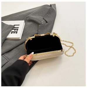 Close-up of evening clutch with silver rhinestones, gold bow clasp and black lining