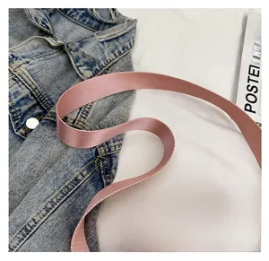 Detailed close-up of the thick pink nylon woven strap on a stylish crossbody bag