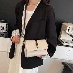 Minimalist cream crossbody square bag with brown accents and gold hardware on model