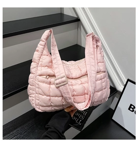 Close-up of pink quilted puffer tote bag featuring front zipper pocket and wide strap