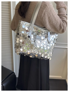 Detail of silver sequin tote bag with Creative Cat metal plaque and chain strap