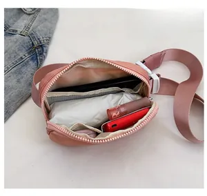 Internal view of pink oxford fabric crossbody bag showing capacity for phone and cosmetics