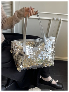 Close-up of silver sequin tote bag showing reflective texture and creative cats label