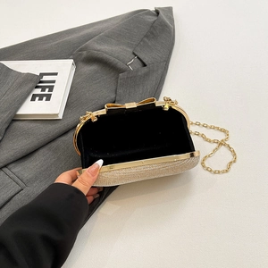 Sparkly evening clutch bag with gold bow clasp and metal chain strap for women