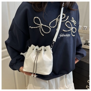 Detail of white wave pattern bucket bag with silver chain and pearl pendants