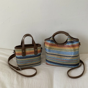 Bunt gestreifte Stroh-Eimertasche mit braunen Ledergriffen und verstellbarem Riemen