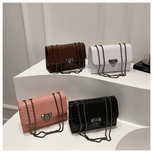 Detail view of four-color faux crocodile leather bags with metal chains and buckle hardware