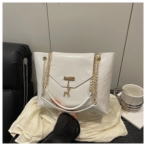 Close-up of white leather chain bag featuring gold reindeer pendant and metal eyelet details