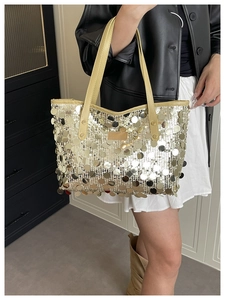 Detail of shimmering silver-gold sequins on large tote bag with leather logo patch