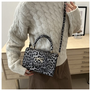 Detailansicht der Schultertasche mit Leopardenmuster, goldener Schließe und Tragegriff