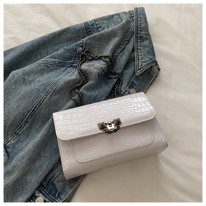 Detailed view of white crocodile pattern PU leather flap bag with vintage metal chain