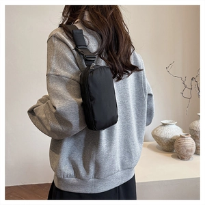 Detail of high-density black nylon fabric and durable strap buckle on a crossbody bag