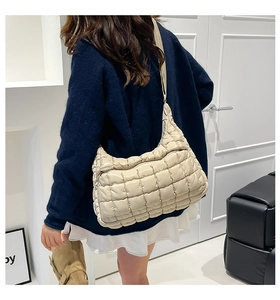 Detailed view of square quilted texture and soft padded fabric on beige tote bag