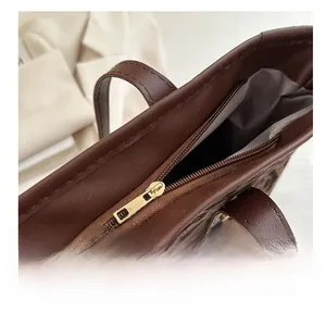 Detailed close-up of smooth gold metal zipper on leopard print shoulder bag