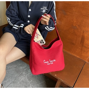 Vue détaillée du grand sac cabas en toile rouge montrant le rangement pour un smartphone
