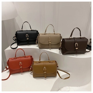 Litchi texture leather handbags in five colors displayed on white curved steps