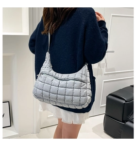 Close-up of quilted light blue nylon tote showing padded square texture and strap