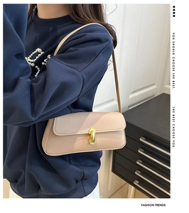 Dettaglio della borsa baguette in pelle beige con raffinata chiusura a scatto dorata