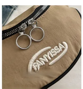 Détail du sac banane kaki avec doubles fermetures éclair argentées et logo brodé en 3D