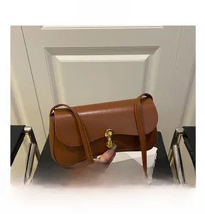 Détail du sac baguette en cuir marron doté d'un fermoir rotatif chic en métal doré