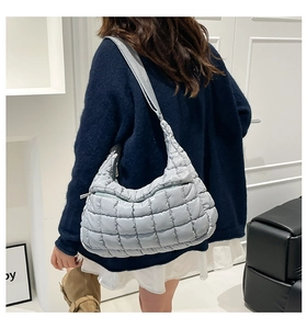 Quilted light blue puffer shoulder bag with a padded crossbody strap and square texture