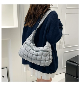 Detailed close-up of light blue quilted nylon tote bag with puff texture and soft strap