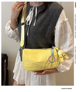 Détail de la broderie CHOU 'DN sur le sac bandoulière jaune en nylon pour femmes