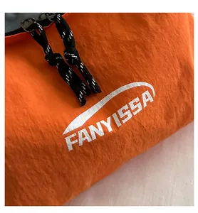 Close-up of orange nylon bag with white FANYISSA logo and black zipper detail