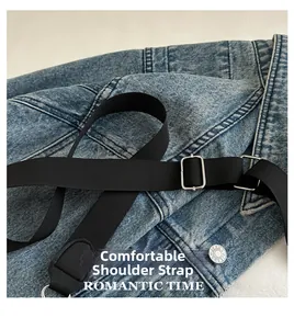 Détail de la bandoulière réglable en nylon noir et boucle métallique sur sac en jean