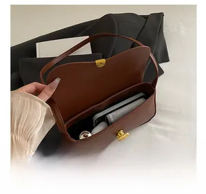 Capacité intérieure détaillée du sac baguette en cuir marron avec son fermoir doré