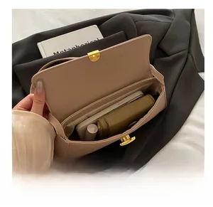 Dettaglio della capacità interna della borsa in pelle beige con telefono e portafoglio