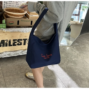 Détail du sac fourre-tout en toile bleu marine avec broderie rouge et tissu très résistant